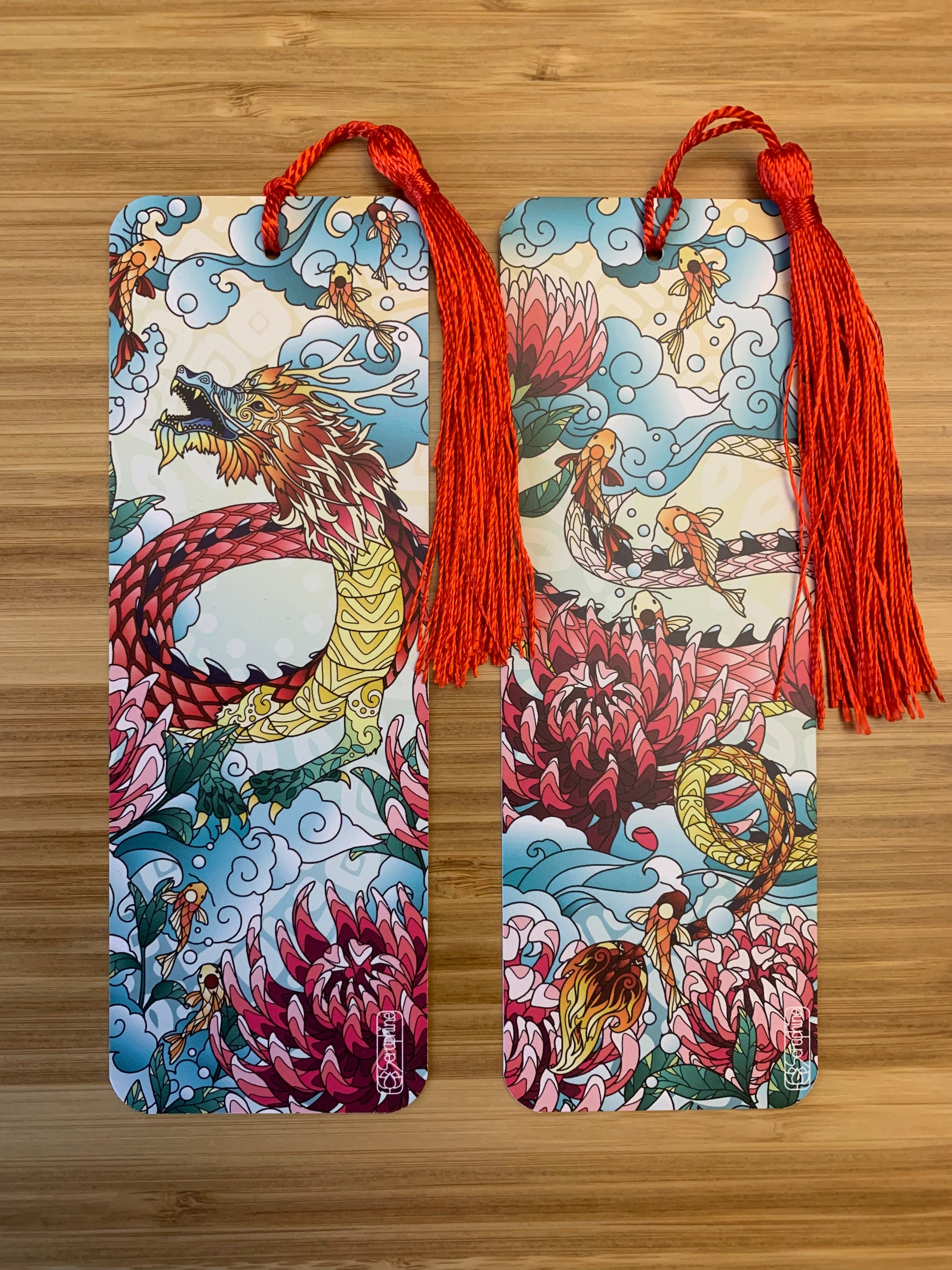 Handgemachtes Lesezeichen mit einem chinesischen Drachen, Chrysanthemen Blüten, Koi Fischen und Wolken als Motiv auf Vorderseite und Rückseite. Rote Quaste als Bändel.